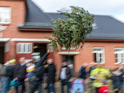 A man completes a throw at the 7th Christmas tree toss at the Cottbus-Ströbitz Fire Depar