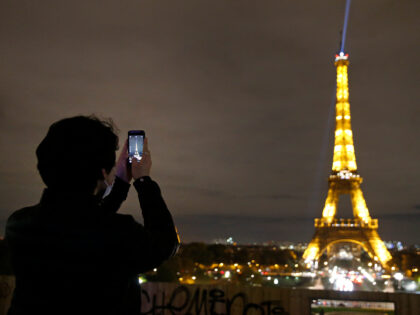 PARIS, FRANCE - OCTOBER 29: A man wearing a protective face mask takes a picture of the il