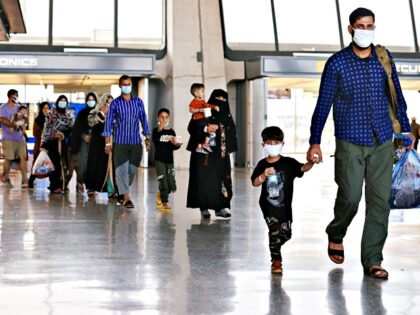 DULLES, VIRGINIA - AUGUST 27: Refugees arrive at Dulles International Airport after being