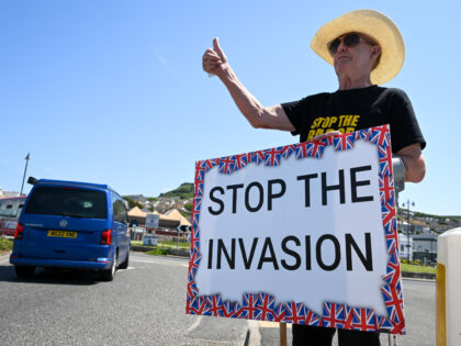 PORTLAND, ENGLAND - JUNE 03: A protester holds a 'Stop the Invasion' sign as local residen