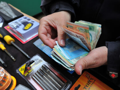 A market trader counts mixed denomination Serbian dinar notes at his stall in Belgrade, Se