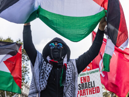 A pro-Palestinian activist holds up a Palestinian flag during a rally outside Downing Stre