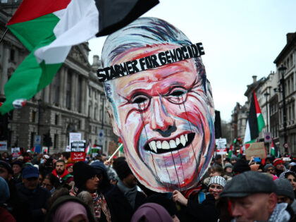 Pro-Palestinian activists and supporters carry a giant mask of Britain's main opposition L