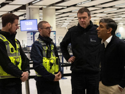 Britain's Prime Minister Rishi Sunak (R) meets with Border Force officers during a visit t