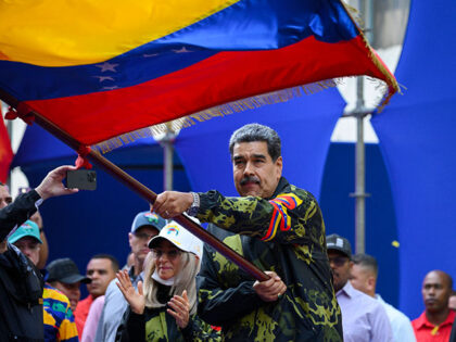 Venezuela's President Nicolas Maduro waves a national flag during a rally in support