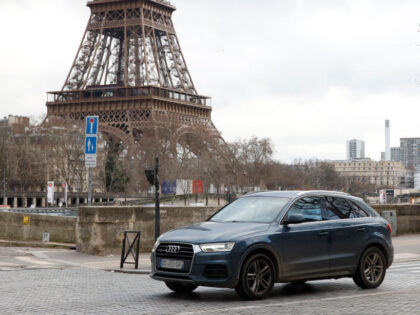 A local resident drives his sport utility vehicle (SUV) in the center of Paris, with the E
