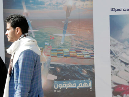 SANA'A, YEMEN - JANUARY 31: A man walks next to a billboard bearing the image of a co