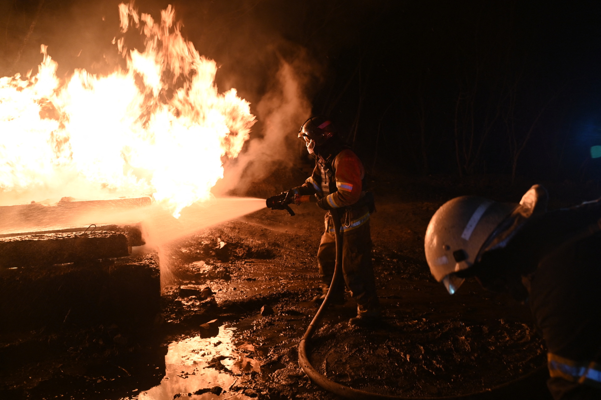 Ukrainian emergency personnel douse water to extinguish flames as they work at the site of a drone attack in Kharkiv, early on February 10, 2024. Seven people, including three children, were killed Saturday in a Russian drone attack on the city of Kharkiv in eastern Ukraine, the regional governor said. "Unfortunately the death toll from the occupiers' attacks on Kharkiv has risen to seven," Oleg Synegubov said on the Telegram social network. "Among them are three children: 7, 4 years old and a baby about six months old." (Photo by SERGEY BOBOK / AFP) (Photo by SERGEY BOBOK/AFP via Getty Images)