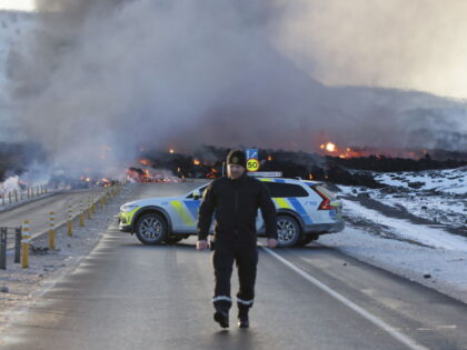 GRINDAVIK, ICELAND - FEBRUARY 8: Emergency services close a road as lava erupts from a fis