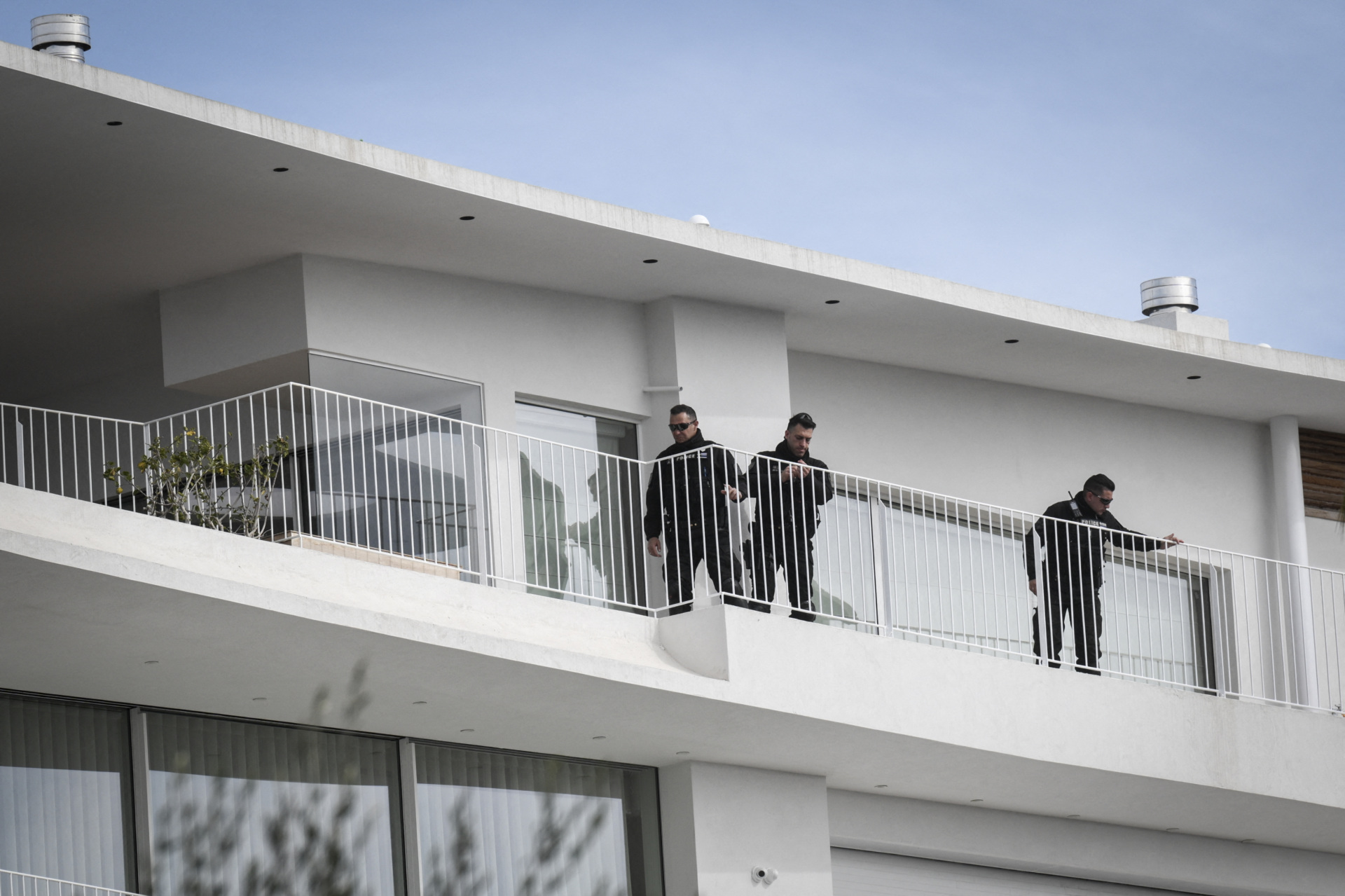 Police officers stand on the balcony of a shipping company, south of Athens, on February 12, 2024. Three people were killed on February 12, 2024, by shots fired by a man who barricaded himself in the premises of a shipping company in the seaside suburb of Athens. (Photo by Angelos Tzortzinis / AFP) (Photo by ANGELOS TZORTZINIS/AFP via Getty Images)