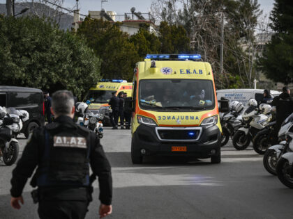 Police officers and ambulances stand at the road outside a shipping company, south of Athe