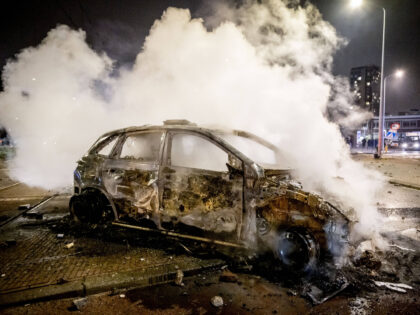 A police car burns at the Opera hall center following clashes between two groups of Eritre