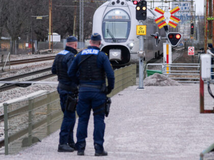 Police officers stand at the site at Sodra station in central Orebro Sweden, where three p