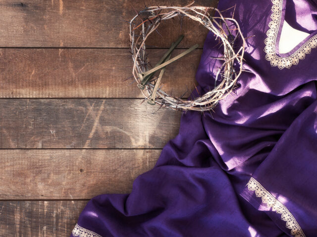 Easter Jesus Crown of Thorns and Nails Lying on a Royal Purple Robe against a Rustic Wood