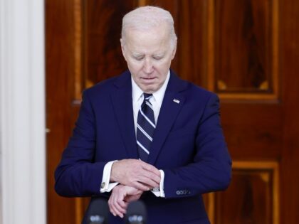 President Joe Biden looks at his watch as he arrives to give remarks with King of Jordan A