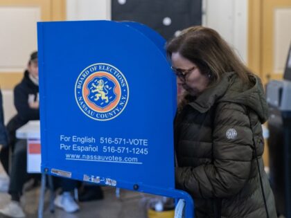 A voter casts a ballot at a polling station inside Robert Finley Middle School in Glen Cov