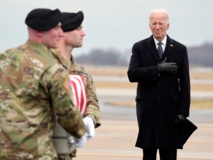 President Joe Biden watches as an Army carry team moves the flag-draped transfer case cont