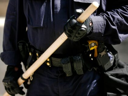 UNITED STATES - AUGUST 31: A police officer holds a nightstick while monitoring a Veterans