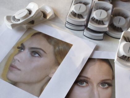 False eyelashes rest on a table backstage before the Zac Posen Spring 2013 collection is m