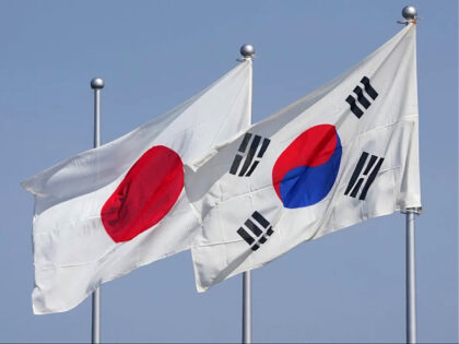 The national flags of Japan (L) and South Korea (R) flutter in the wind ahead of the arriv