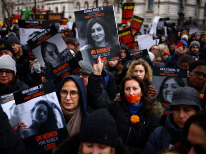 Demonstrators hold posters of women being held hostage in Gaza during a rally in London on
