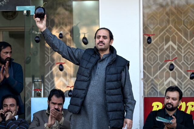 Aamir Mughal (C) brandishes an eggplant, rallying support behind the Pakistani staple duri