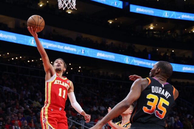 Atlanta point guard Trae Young drives against Kevin Durant and Grayson Allen in the Hawks'