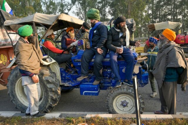 Farmers sit on their tractors near the Haryana-Punjab state border at Shambhu, stalled by