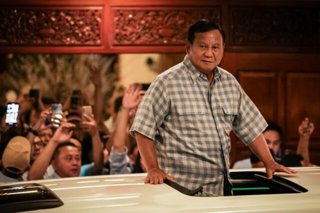 Indonesian presidential candidate Prabowo Subianto reacts to cheering supporters from a ca