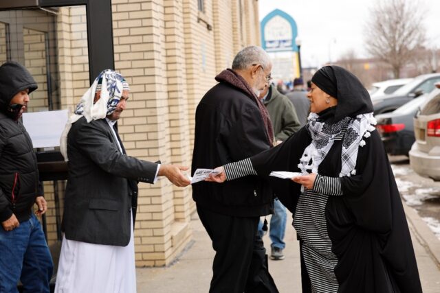 Samra'a Luqman hands out fliers outside of a mosque in Dearborn, Michigan, asking voters n