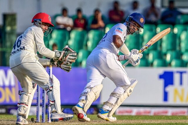 Sri Lanka's Dimuth Karunaratne (R) plays a shot as Afghanistan's wicketkeeper Ikram Alikhi