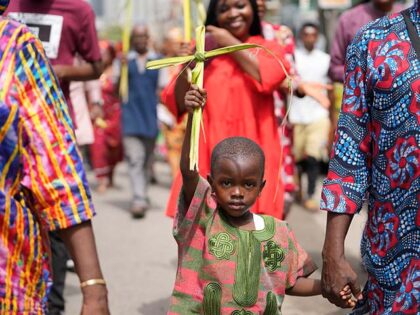 A child carries Palm fronds to commemorate Palm Sunday, which marks the entry of Jesus Chr