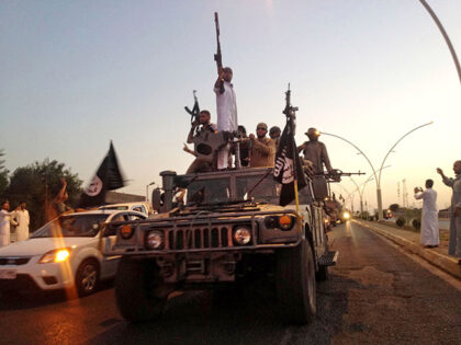 In this June 23, 2014 file photo, fighters from the Islamic State group parade in a comman