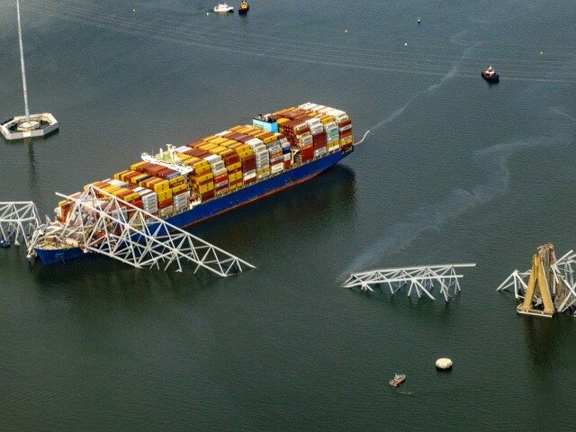 In an aerial view, the cargo ship Dali sits in the water after running into and collapsing
