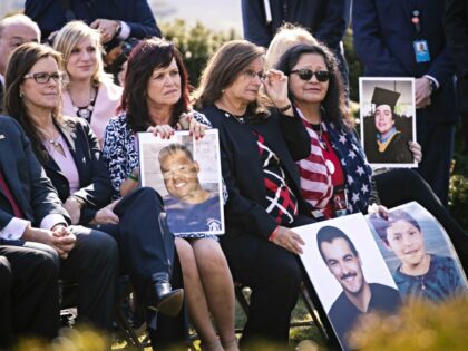 "Angel Moms" hold photos of family members that were killed as U.S President Don