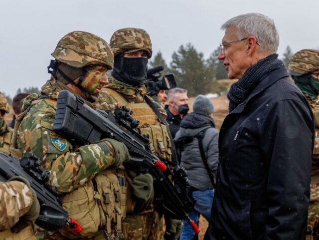 Latvia's Prime Minister Krisjanis Karins talks with soldiers during a visit of the Ad