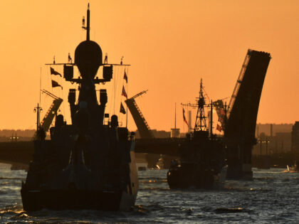 Russian warships sail on the Neva river through raised drawbridges during a rehearsal for