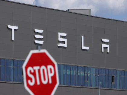 GRUENHEIDE, GERMANY - JULY 17: A stop sign stands near the Tesla logo at the Tesla factory