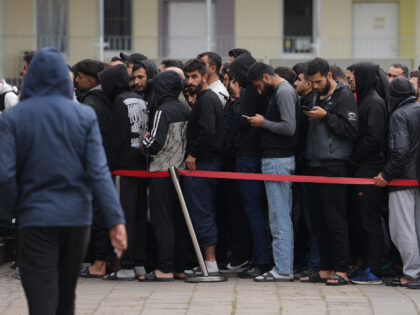 EISENHUETTENSTADT, GERMANY - OCTOBER 05: Men, most of them from Syria, queue for lunch at