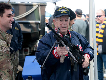 A Navy submarine veteran checks out a gun in the Fan Zone before the 124th playing of Amer