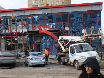 Specialists of various services work by a damaged shopping centre following an air attack