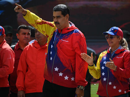 Venezuelan President Nicolas Maduro (C) and First Lady Cilia Flores (R) greet supporters d