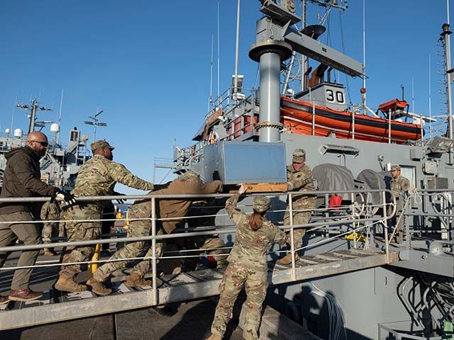 US Army soldiers load an AC unit aboard the USAV Monterey at the pier of the Joint Base La