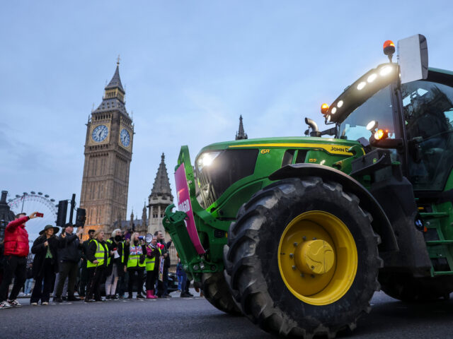 A farmer drives their tractor past the Houses of Parliament during a protest against issue