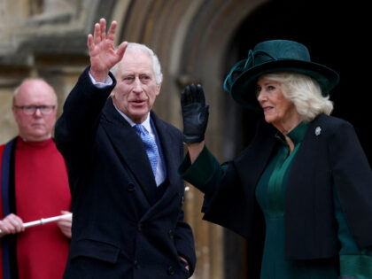 Britain's King Charles III (C) and Britain's Queen Camilla (R) waves as they arrive at St.