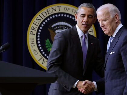U.S. President Barack Obama (L) shakes hands with Vice President Joe Biden before signing