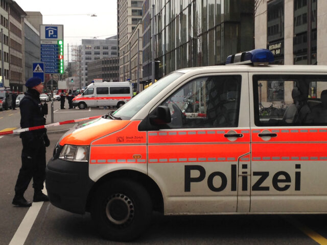 Police officials gather at the scene of a shooting outside a branch of UBS bank in Zurich