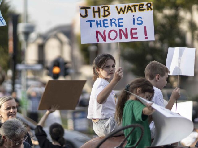 Residents hold placards during a protest against no access to water in the area in Blairgo