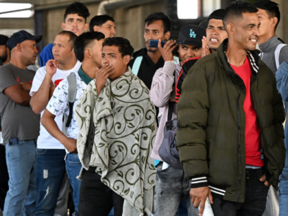 Venezulean migrants wait in a line to get paper work to be admitted to shelters at a migra