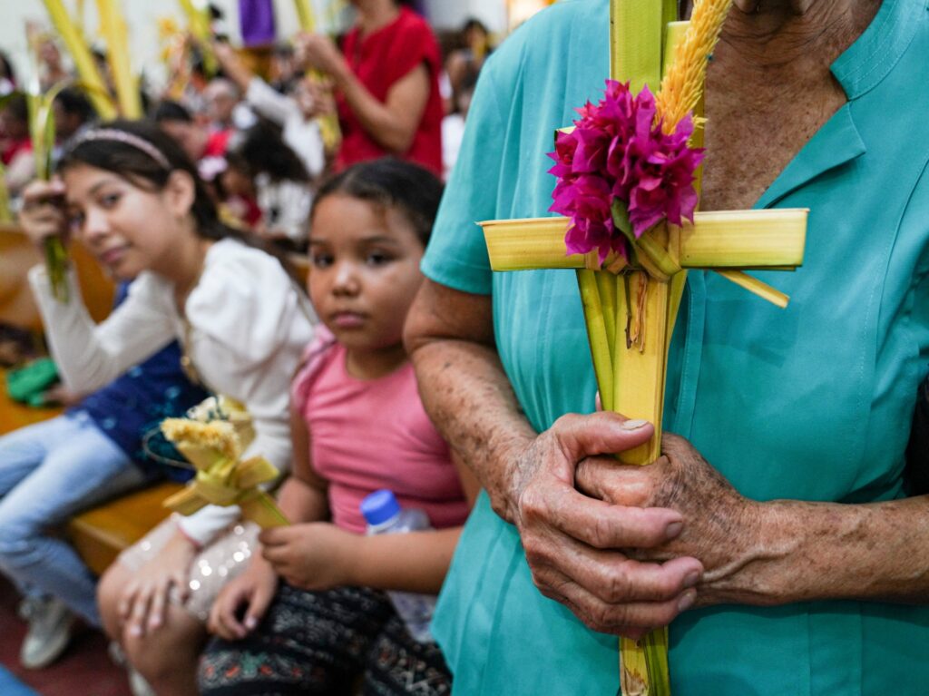 A woman holds palm crosses to be blessed during a Palm Sunday mass at the Metropolitan Cathedral in Managua on March 24, 2024. (Photo by OSWALDO RIVAS / AFP)